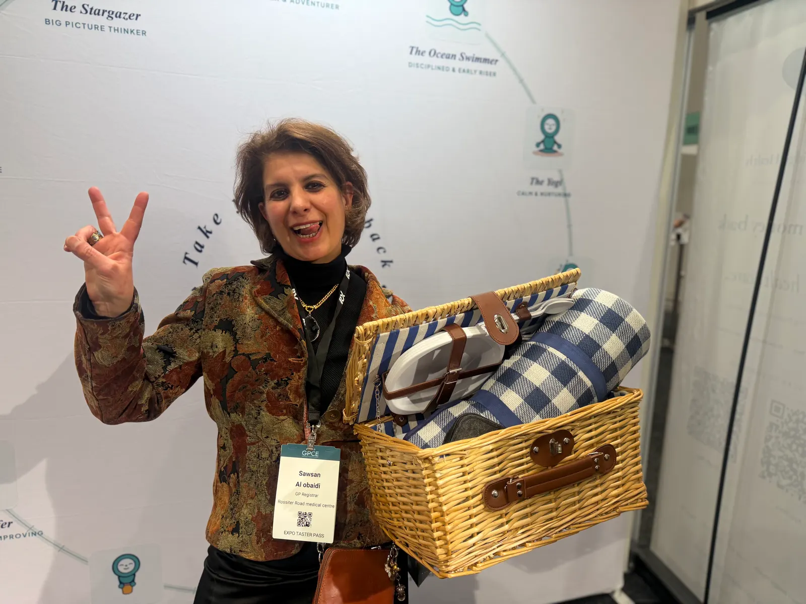 A smiling delegate holding up a picnic hamper she has just won at the Heart Bridge Health stand