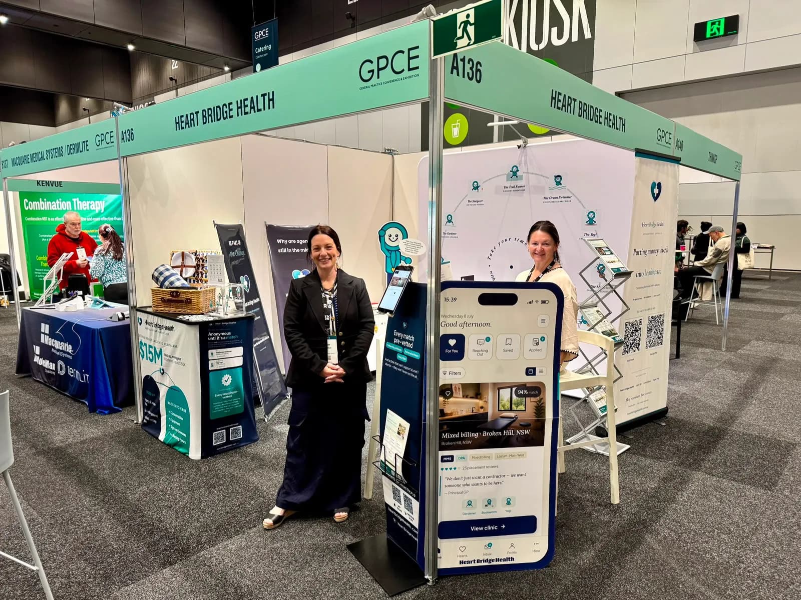 The Heart Bridge Health team at their GPCE stand beside a large display of the marketplace app