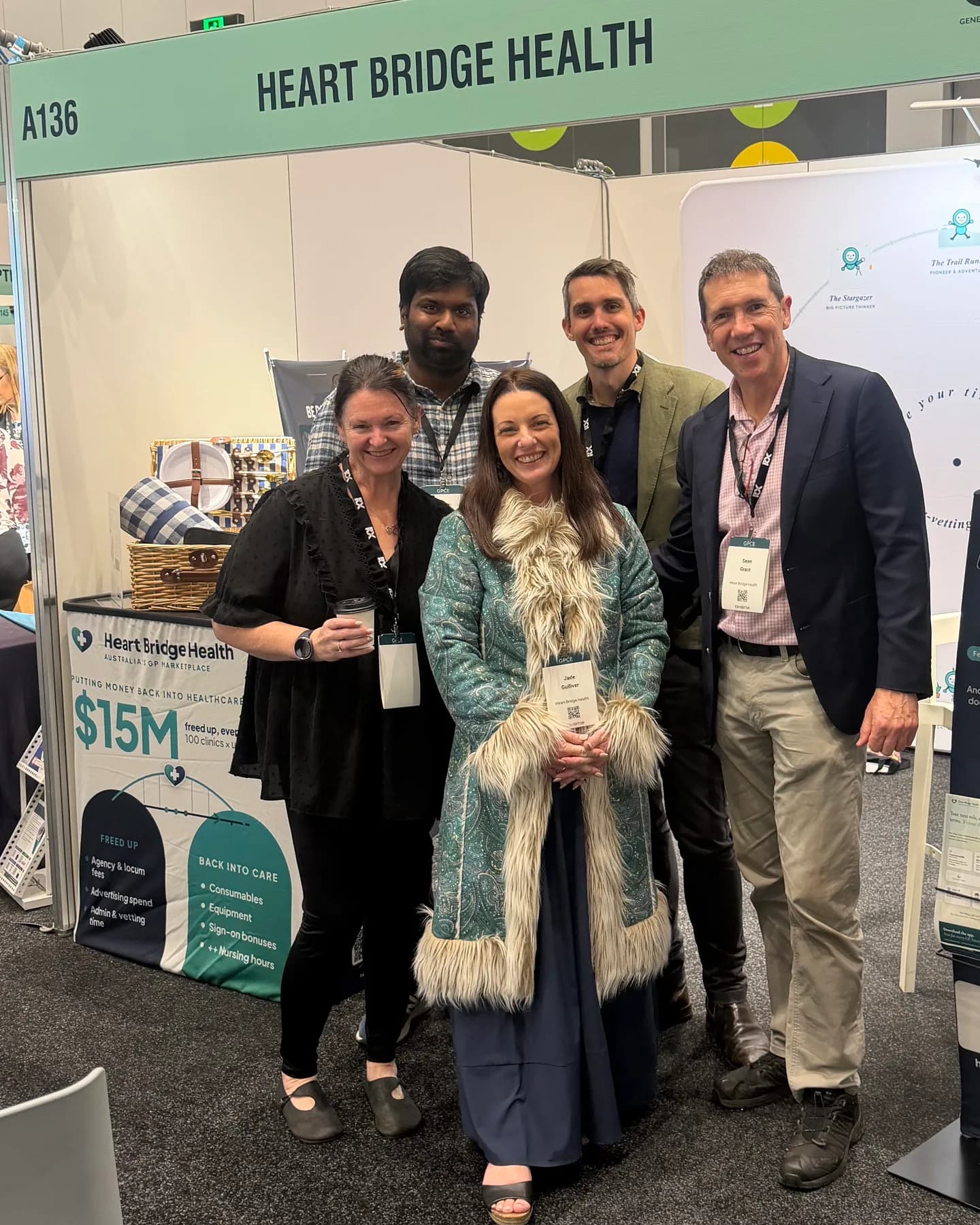 The Heart Bridge Health team at the GPCE stand, beside a display of the marketplace app
