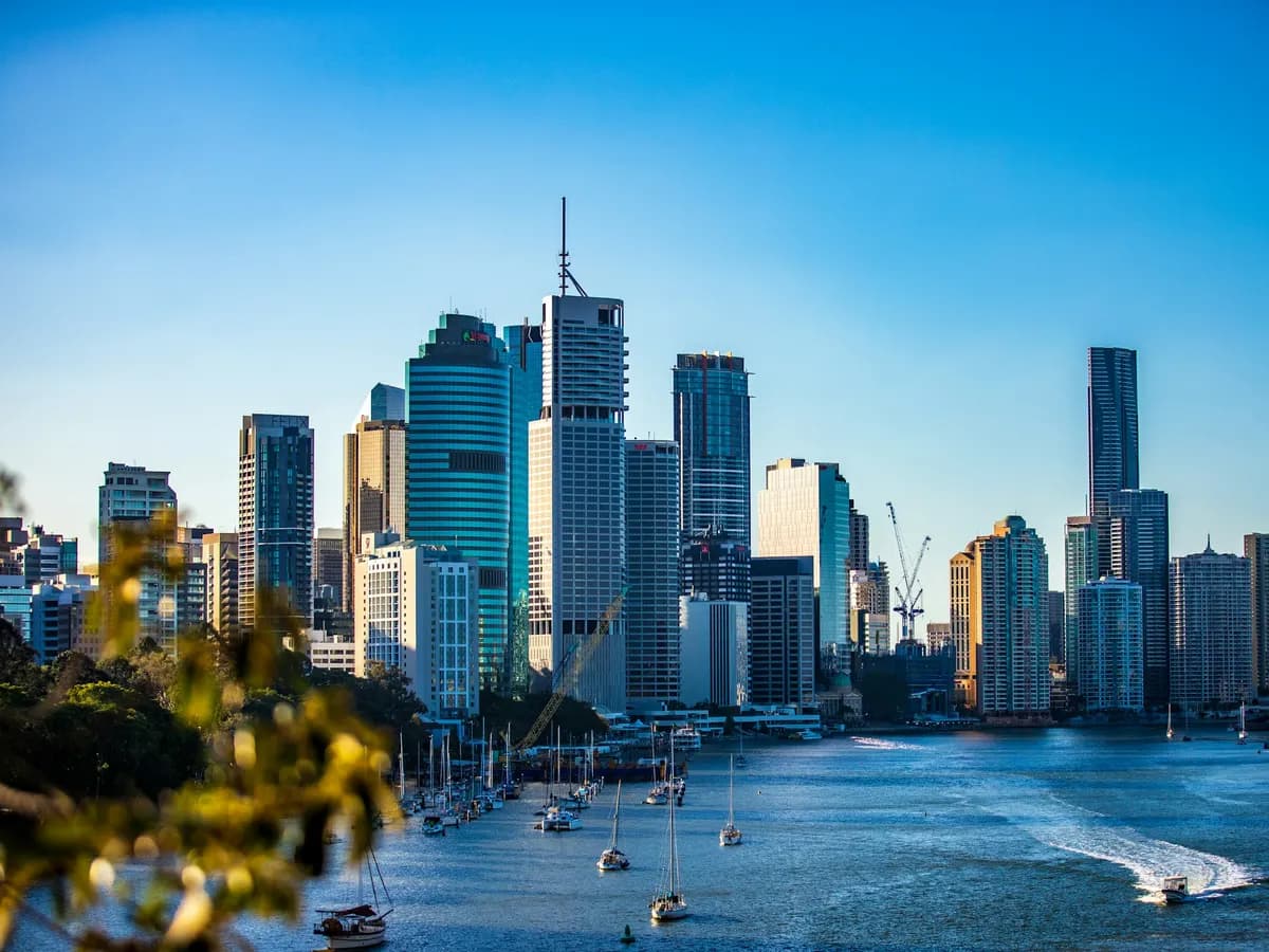 The Brisbane CBD skyline seen across the Brisbane River on a clear day, with yachts moored in the foreground
